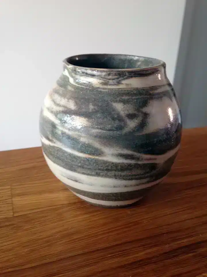 Een bolle vaas gemaakt met verschillende kleuren klei gemengd