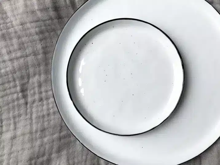 Twee witte borden in keramiek met een zwart randje