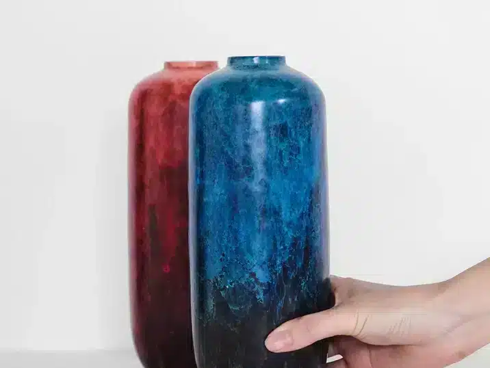 Een rode en blauw hoge smalle vaas van keramiek