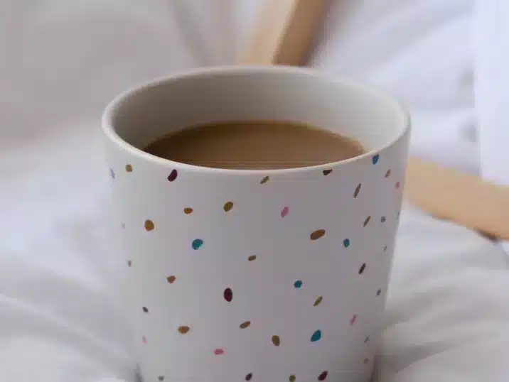 Een wit koffiekopje van keramiekbeschilderd met gekleurd kleislib