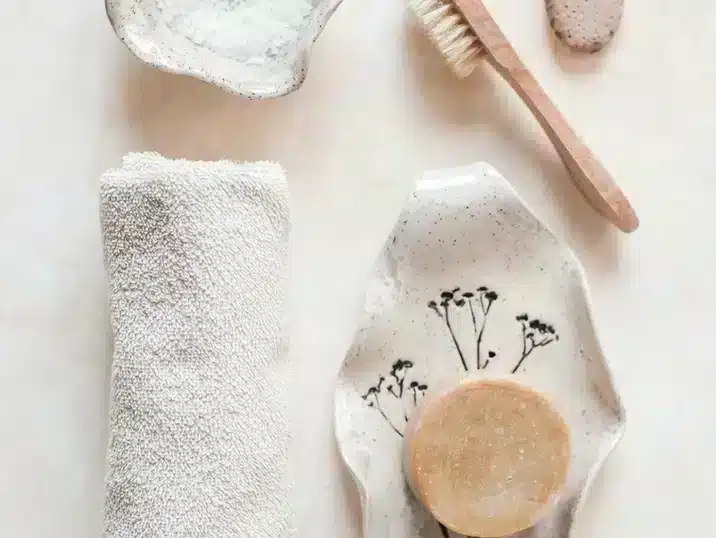 Een zeepbakje gemaakt van keramiek bij een handdoek en borstel