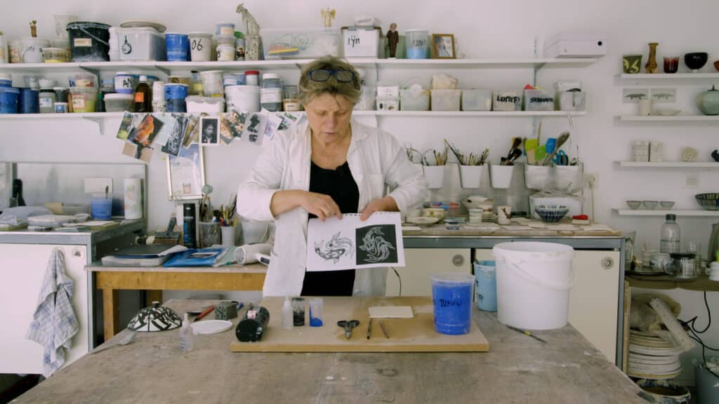 Cursist docent Anima Roos toont in haar atelier een laserpinttekening van twee vissen