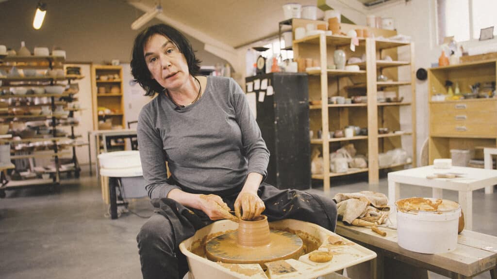 Cursist docente Françoise Busin in haar atelier aan de draaischijf