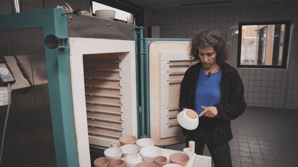 Cursist docente Caroline Kestelyn tijdens het inladen van potten voor de keramiekoven