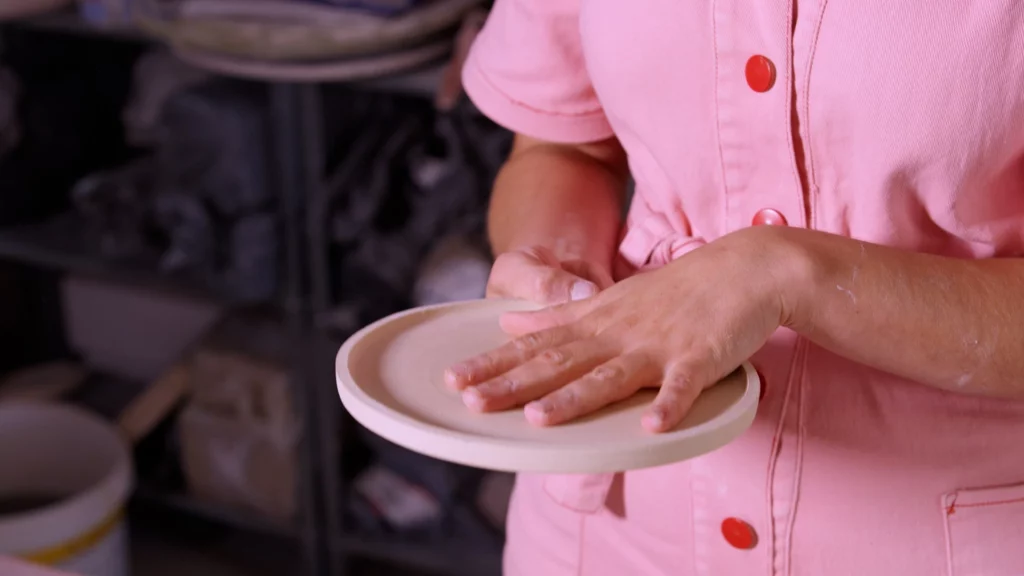 Sofie De Cleene heeft een bord in haar handen en legt haar linker hand er op