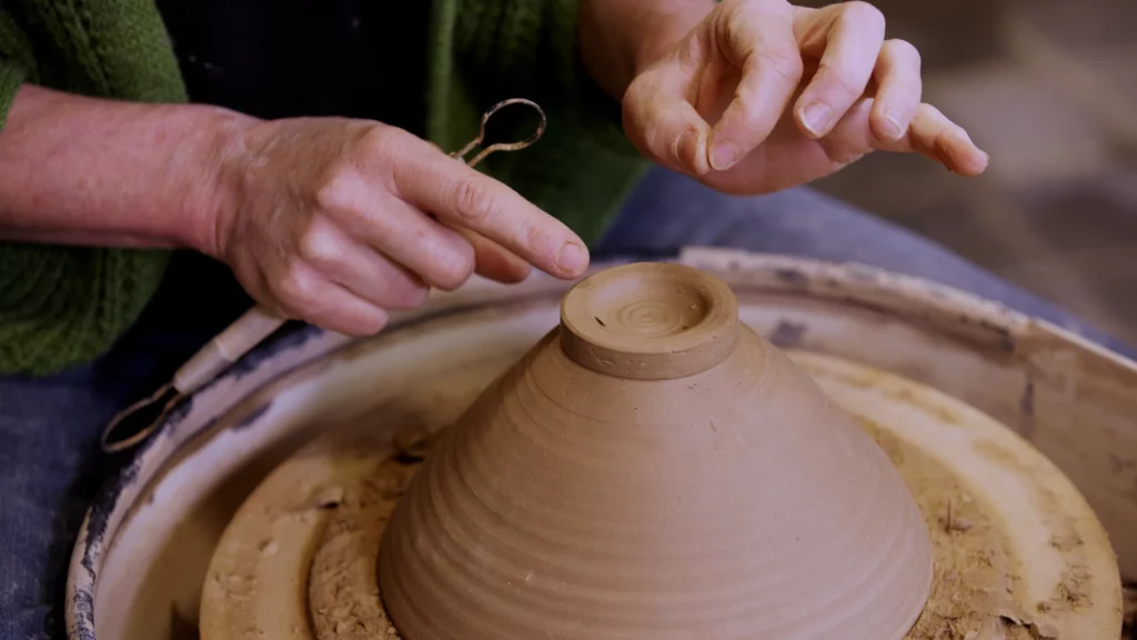 Aster Caemaert toont een voet aan een pot